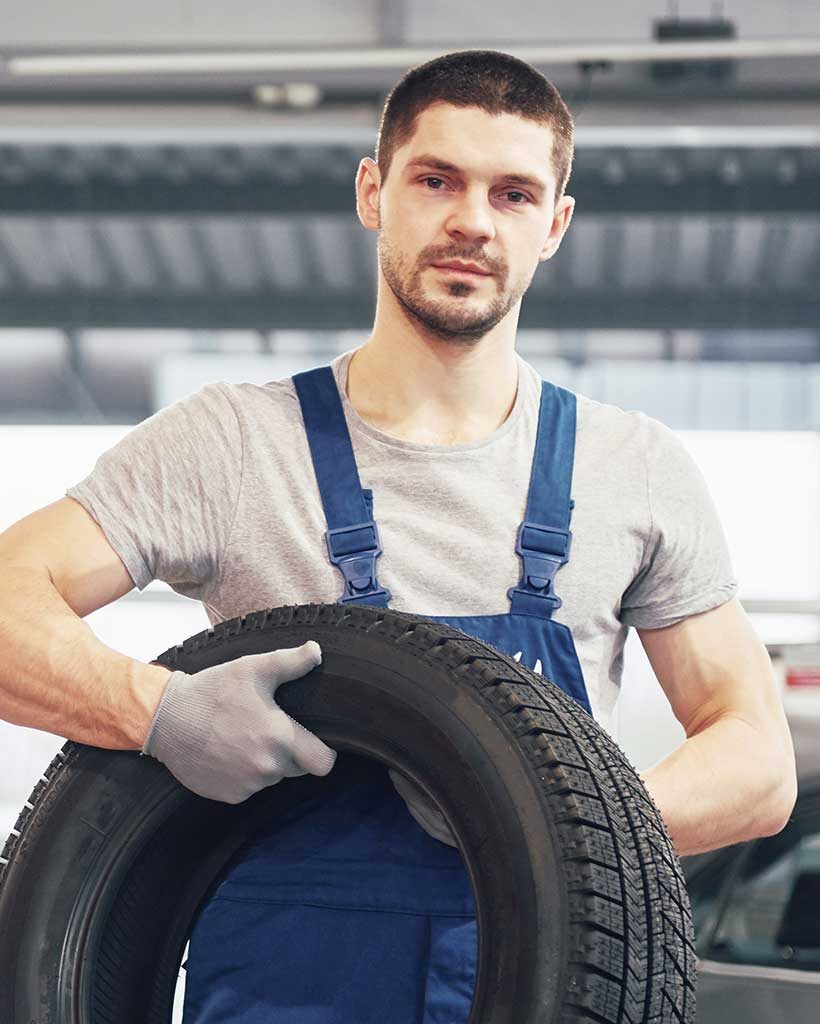 mechanic-holding-a-tire-tire-at-the-repair.jpg